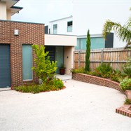 Exposed aggregate driveway, with brick retaining wall to match house.