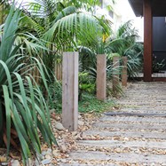 Natural sleeper and gravel path with vertical timber uprights leading to front door.