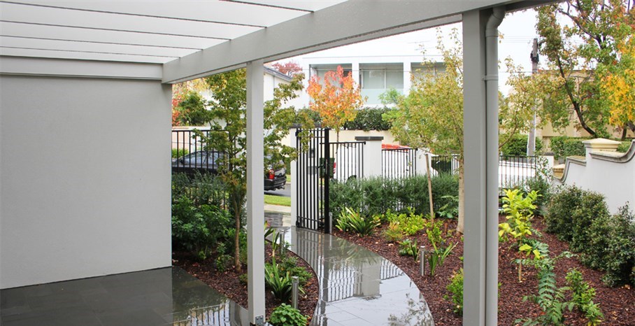 Cohesion garden design in Melbourne, random rectangular paving entrance with wrought iron fence and gates.  Planted as too soften building lines. Modern garden design, modern gardens, modern garden design ideas, garden makeover.